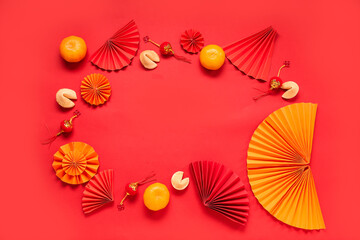 Frame made of fortune cookies with mandarins and Chinese symbols on red background. New Year celebration