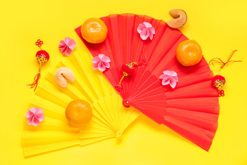 Fortune cookies with mandarins and Chinese symbols on yellow background. New Year celebration
