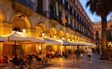 Nightlife at Placa Reial in Barcelona. Illuminated central city square crowded with people enjoying...