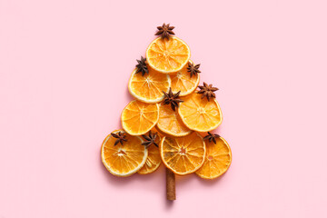 Christmas tree made of dried orange slices with star anise and cinnamon on pink background
