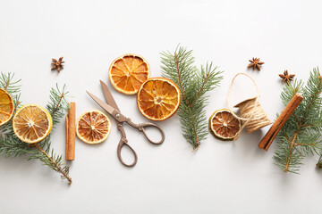 Obraz na płótnie Canvas Dried orange slices with fir branches, cinnamon and star anise on grey background