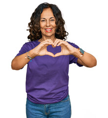 Middle age hispanic woman wearing casual clothes smiling in love doing heart symbol shape with hands. romantic concept.