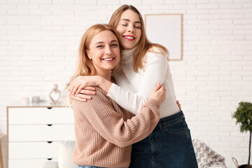 Happy young woman hugging her mother at home. International Hug Day