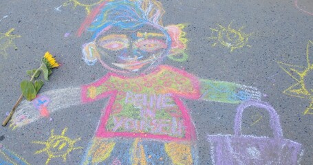Colorful chalk drawing of person on asphalt, created with chalk. No people. This artwork involves vibrant and imaginative representations of people, found in public spaces, sidewalks or playgrounds.