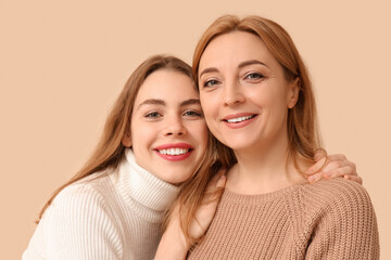 Happy young woman hugging her mother on beige background. International Hug Day