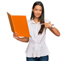 Beautiful hispanic woman reading book pointing finger to one self smiling happy and proud