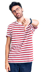 Young hispanic man wearing casual clothes looking unhappy and angry showing rejection and negative with thumbs down gesture. bad expression.