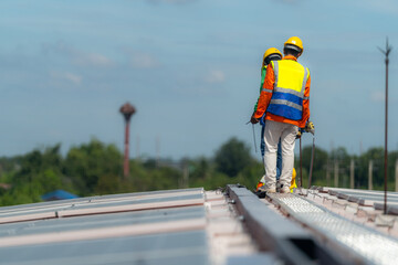 Worker Technicians are working to construct solar panels system on roof. Installing solar photovoltaic panel system. Alternative energy ecological concept. Renewable clean energy technology concept.