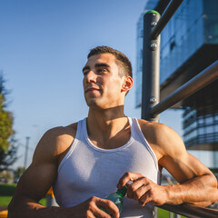 man young male athlete hold bottle of water drink training outdoor