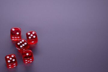 Red dices on grey background. Copy space.