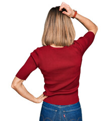 Young blonde girl wearing casual clothes backwards thinking about doubt with hand on head