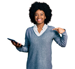 Young african american woman using touchpad device pointing finger to one self smiling happy and...