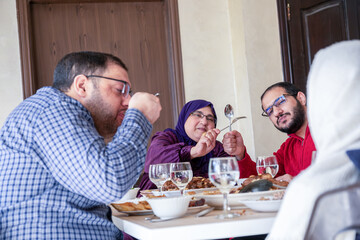 Family eating together with multi generation members in modern living room