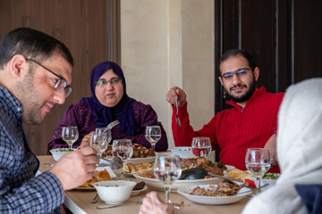 Family eating together with multi generation members in modern living room