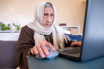 old lady using laptop in modern living room for online purposes