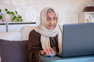 old lady using laptop in modern living room for online purposes