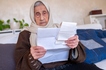 old lady holding receipt checking costs of living and house rent and her debts