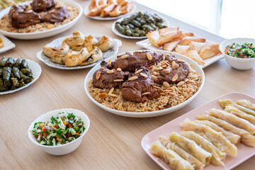 arabian dining table consist of rolls of cabbage rolls of grape , rice ,chicken, sambousek and qatayef without people