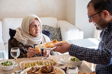 Family eating together with multi generation members in modern living room