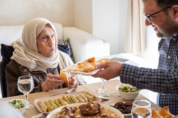 Family eating together with multi generation members in modern living room