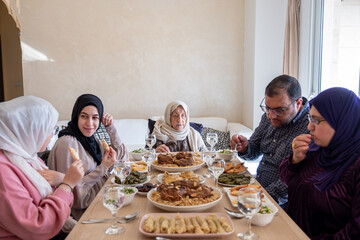 Family eating together with multi generation members in modern living room