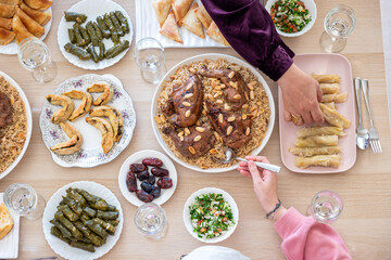 top view Arabian family having dinner together on wooden table with father,mother,grandfather,grandmother and son