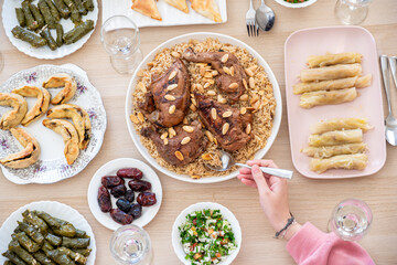 top view Arabian family having dinner together on wooden table with father,mother,grandfather,grandmother and son