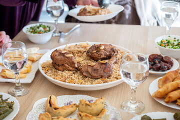 Arabian family having dinner together on wooden table with father,mother,grandfather,grandmother and son