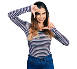 Beautiful hispanic woman wearing casual striped shirt smiling making frame with hands and fingers with happy face. creativity and photography concept.