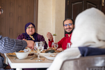Family eating together with multi generation members in modern living room