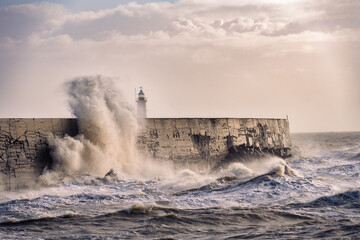 Stormy weather in Newhaven, East Sussex, England in autumn. View of the jetty and the lighthouse.