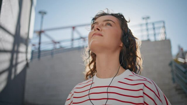 Headphone girl relaxing sunlight moving in tact song outdoors close up.