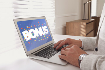 Bonus gaining. Man using laptop at white table indoors, closeup. Illustration of falling confetti...