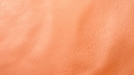 A close up of an orange leather material. Monochrome peach fuzz background.