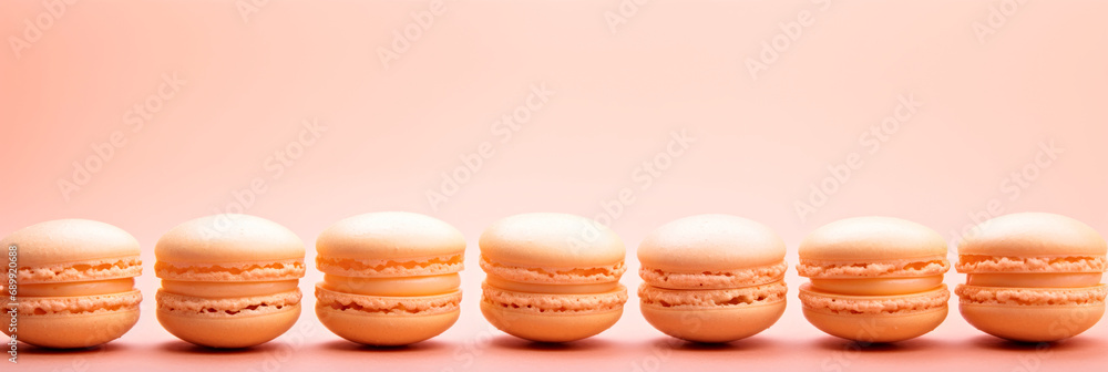 Poster a row of macarons sitting next to each other. monochrome peach fuzz background.