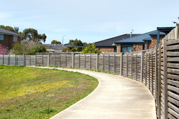 Peaceful pedestrian path adorned with a classic fence - 689920631