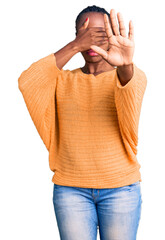 Young african american woman wearing casual clothes covering eyes with hands and doing stop gesture with sad and fear expression. embarrassed and negative concept.