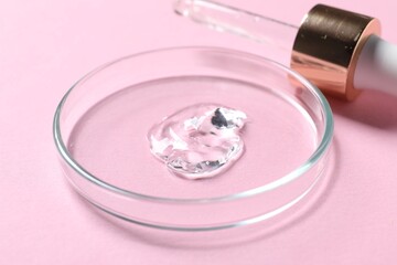 Pipette and petri dish with serum sample on pink background, closeup