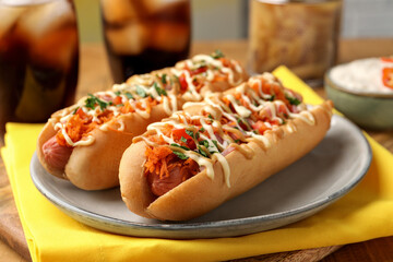 Delicious hot dogs with bacon, carrot and parsley on table, closeup