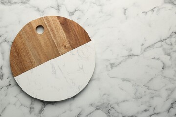 Serving board on white marble table, top view. Space for text