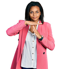 Beautiful hispanic woman wearing business jacket doing time out gesture with hands, frustrated and...