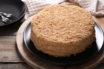 Delicious Napoleon cake on wooden table, closeup