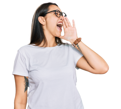 Young hispanic woman wearing casual white t shirt shouting and screaming loud to side with hand on mouth. communication concept.