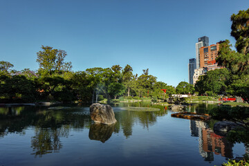 Lago del Jardín Japonés en la ciudad de Buenos Aires rodeado de árboles e infraestructura con...