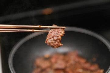 Korean BBQ, marinated meats grilling on a hot plate, emitting flavorful smoke, vibrant colors in a bustling eatery