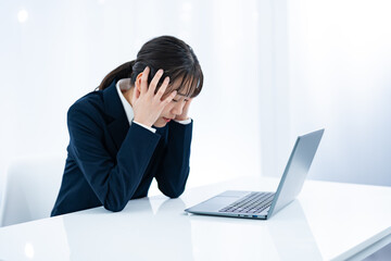パソコンを前に頭を抱える女性