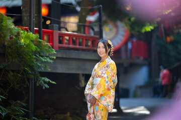 Asian woman try to wear Japanese kimono with the traditional Japanese village background