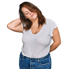 Young plus size woman wearing casual white t shirt suffering of neck ache injury, touching neck with hand, muscular pain