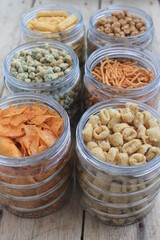 Rows of Indonesian various snacks in jars on the  table 