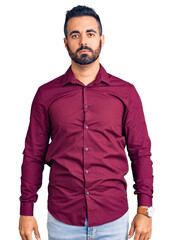 Young hispanic man wearing casual clothes with serious expression on face. simple and natural looking at the camera.